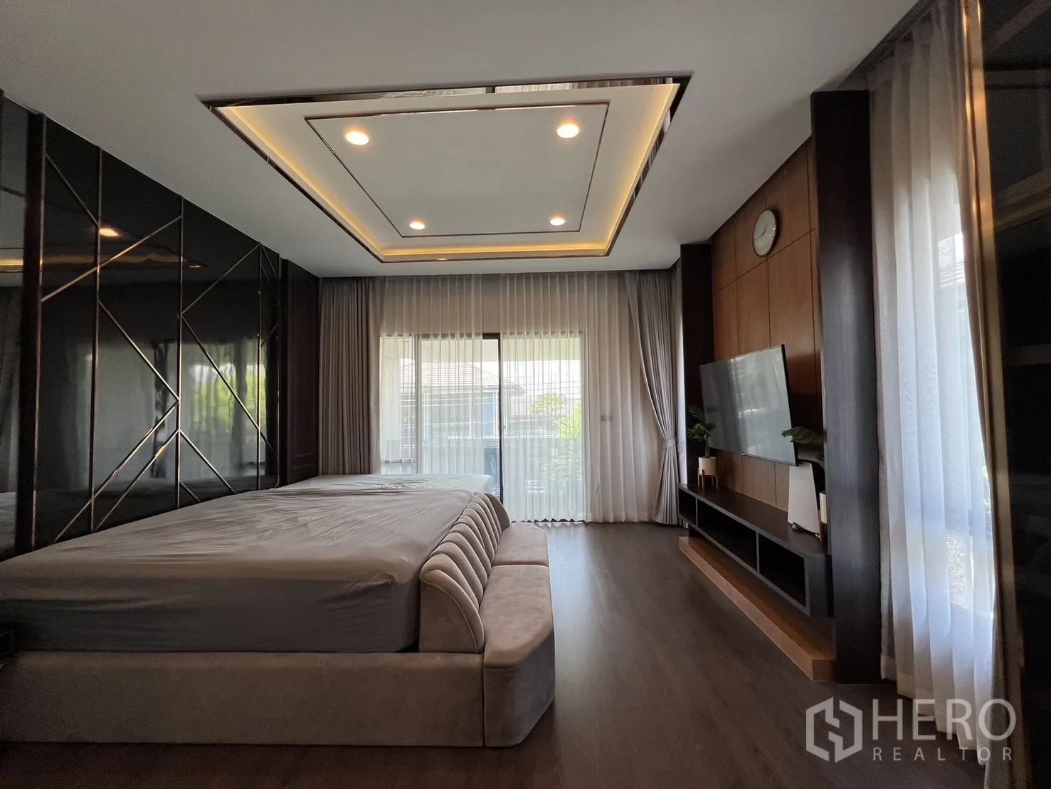 Detached House for rent or sale in Bang Kapi, Bangkok - Master bedroom side view with decorative black feature wall and TV unit.