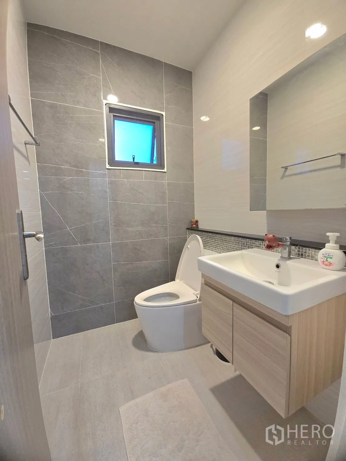 Detached House for rent in Lat Krabang, Bangkok - Compact bathroom with grey feature wall and floating vanity.