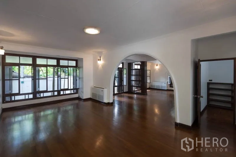 Detached House for rent in Pathum Wan, Bangkok - Open-plan lounge with arched doorway and wall-to-wall windows bringing in light.