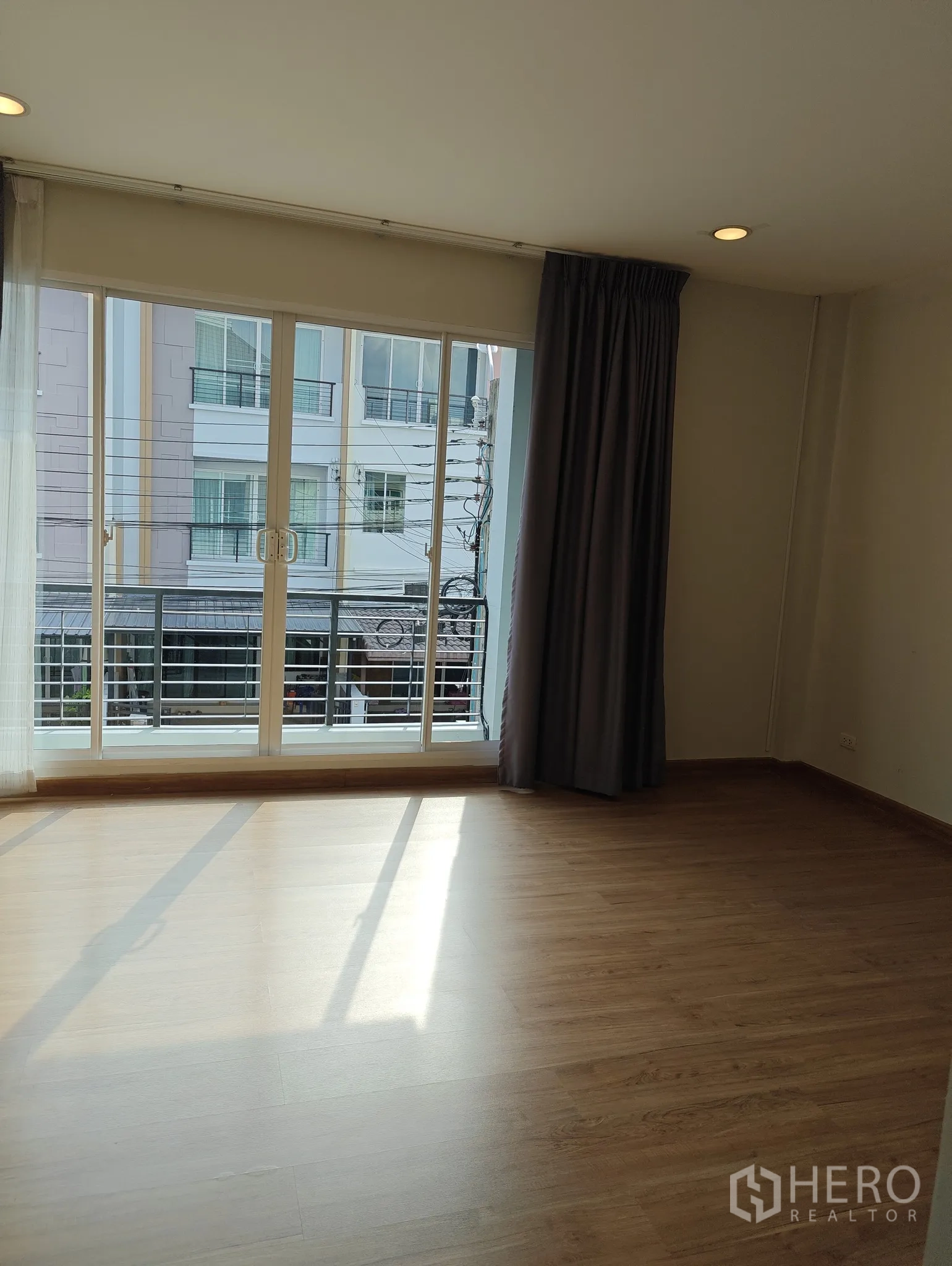 联排别墅 出租或出售在Lat Phrao, Bangkok - 采光充足的卧室，木地板，落地推拉门连阳台，眺望社区景观。