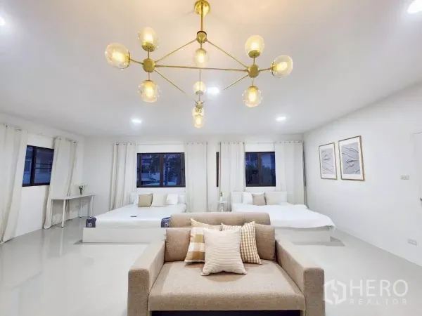Detached House for rent in Chatuchak, Bangkok - Spacious bedroom suite with chandelier, two beds, sofa seating and large windows.