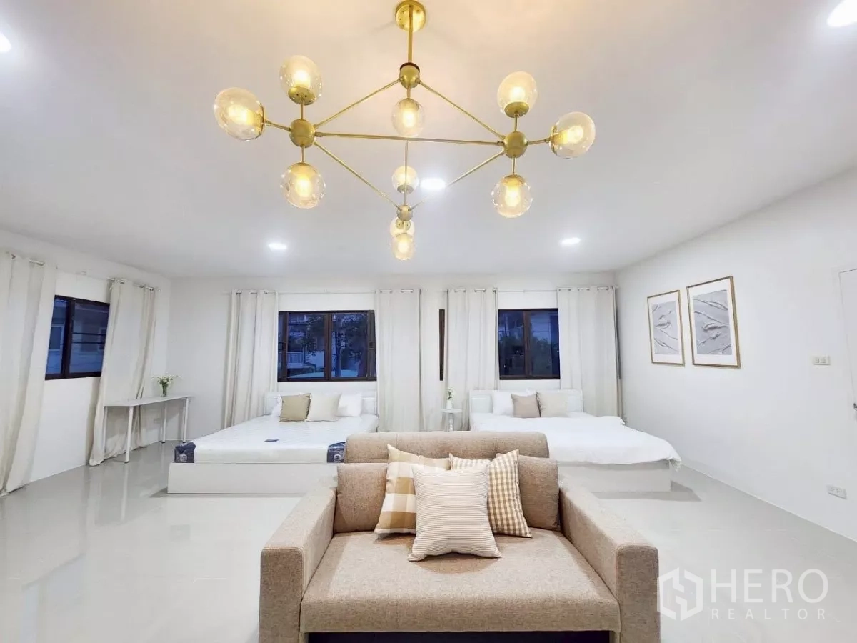 Detached House for rent in Chatuchak, Bangkok - Spacious bedroom suite with chandelier, two beds, sofa seating and large windows.