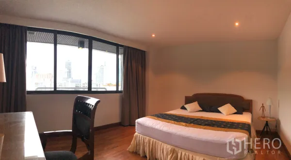 คอนโด ให้เช่าในKhlong Toei, Bangkok - ห้องนอนหลัก เตียงคิง โต๊ะทำงาน และหน้าต่างบานใหญ่ชมวิวสกายไลน์กรุงเทพฯ