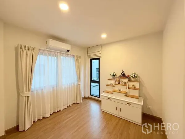 Detached House for sale in Bang Phli, Samut Prakan - Bright multi-purpose room with wood flooring, air conditioner and large curtained window.