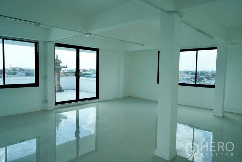 Office Space for sale in Khan Na Yao, Bangkok - Bright open-plan office with glossy tile floors, columns, and sliding glass doors to a terrace with city views.