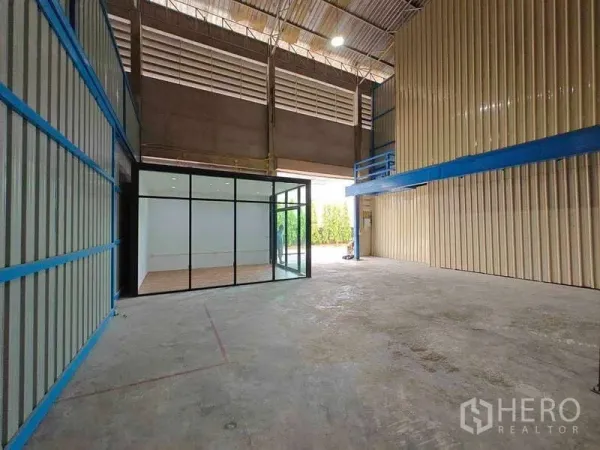 Warehouse for rent in Sam Phran, Nakhon Pathom - Warehouse interior showing a glass-walled office, mezzanine platform and drive-through access.