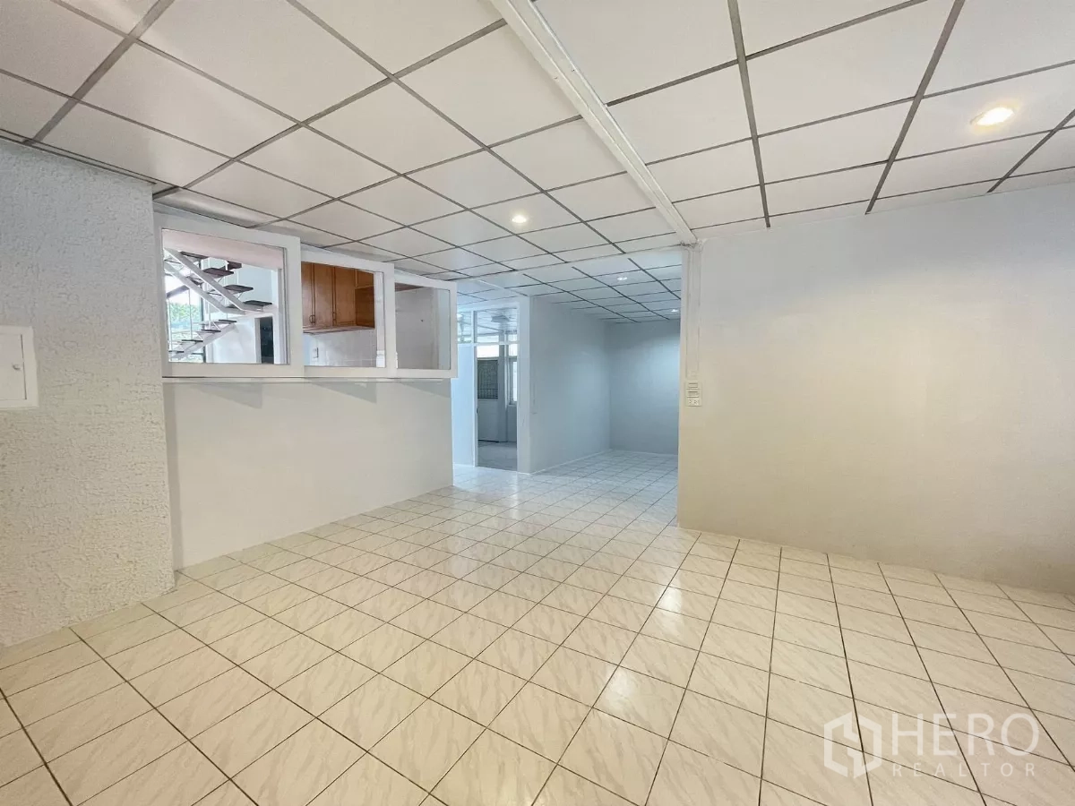 带办公室的家 出租在Din Daeng, Bangkok - 一层开放式空间，瓷砖地面，内窗分隔，可见楼梯方向。