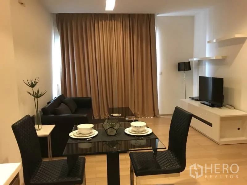 คอนโด ให้เช่าในKhlong Toei, Bangkok - โซนรับแขกและทานอาหารแบบโอเพ่นพลาน โต๊ะกระจก ทีวีและชั้นวาง ผ้าม่านสูงจรดเพดาน