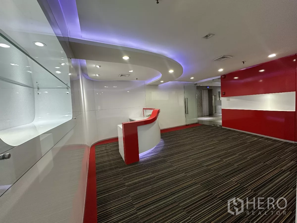สำนักงาน ให้เช่าในWatthana, Bangkok - โถงต้อนรับโต๊ะเคาน์เตอร์โค้ง สีขาว‑แดง ประตูบานกระจก และไฟฝังฝ้า