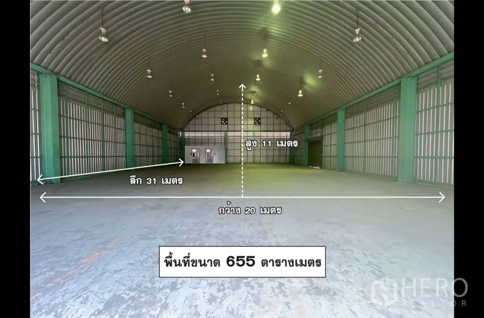 Warehouse for rent in Lak Si, Bangkok - Open warehouse interior with high arched ceiling, concrete floor, lighting and measurement labels.