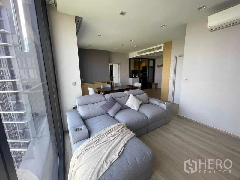 公寓 出租 - 宽敞客厅，L型沙发紧邻通高玻璃窗。