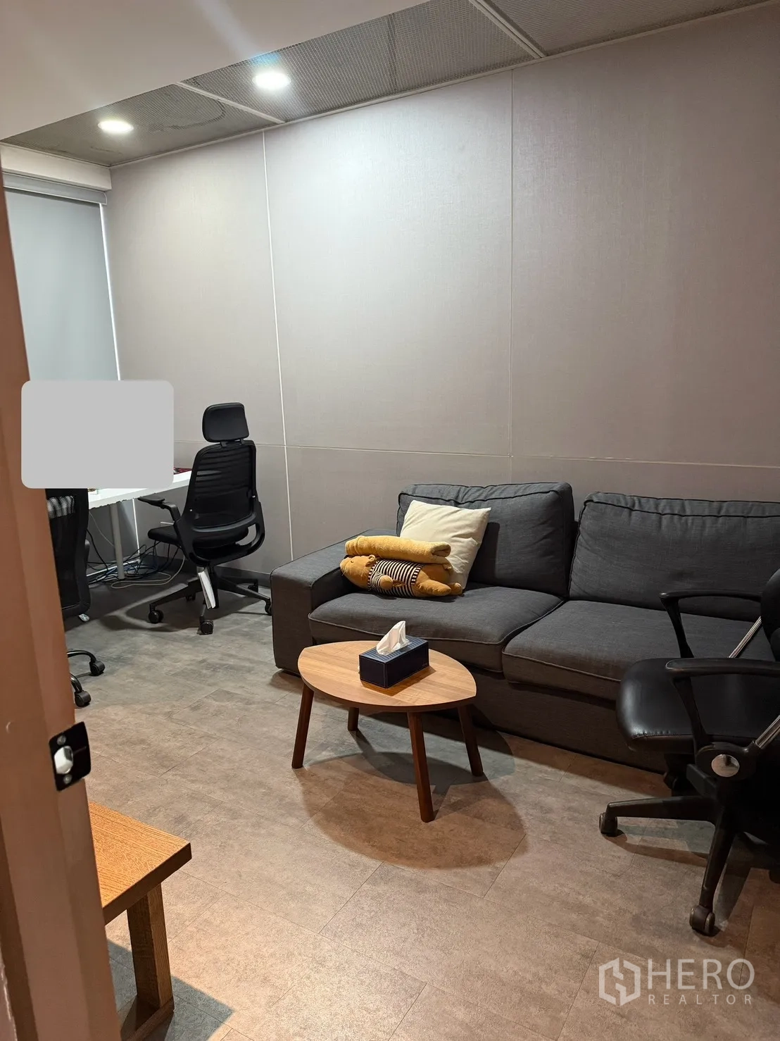 家庭办公室 for rent in Watthana, Bangkok - 小型会议室配灰色沙发、办公椅与圆形茶几，灯光柔和。