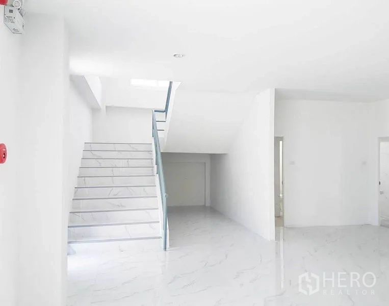 Warehouse for rent in Samut Prakan - Ground floor entry with staircase and under-stair storage area in white finish.