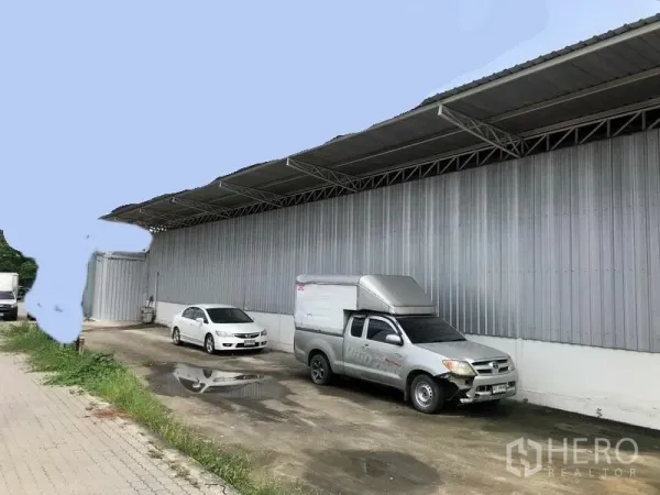 货栈 出租在Pak Kret, Nonthaburi - Pak Kret金属外墙仓库外观，带遮雨装卸区与停车位，位于暖武里府。