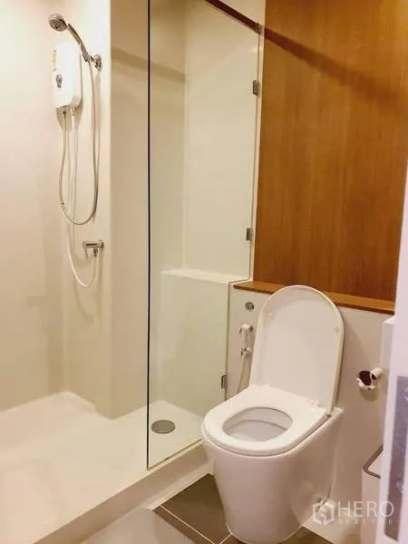 Condominium for rent in Sathon, Bangkok - Clean bathroom with walk-in shower, glass partition and toilet.