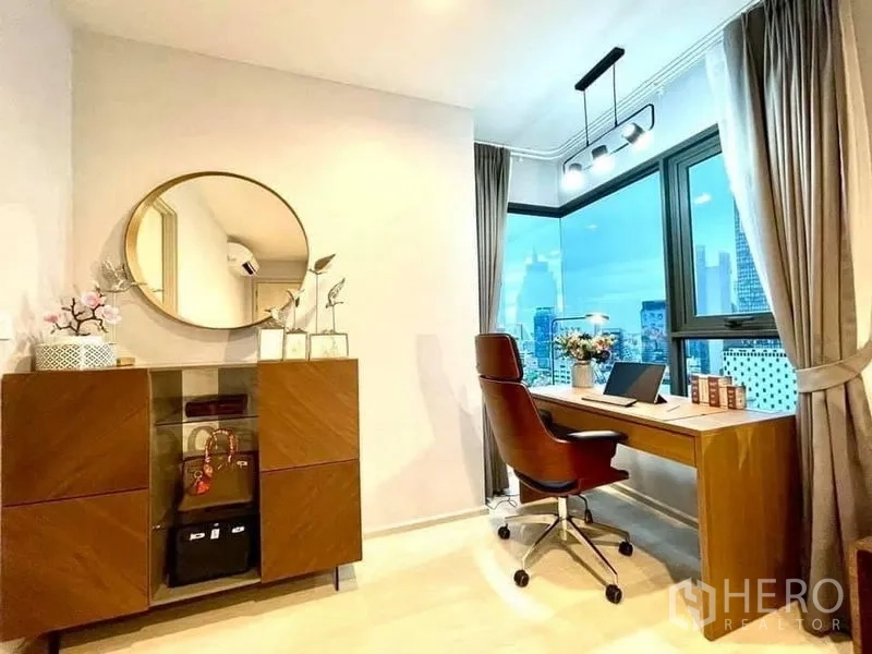 Condominium for rent in Pathum Wan, Bangkok - Corner home office with L-shaped windows, wood desk and sweeping city views.