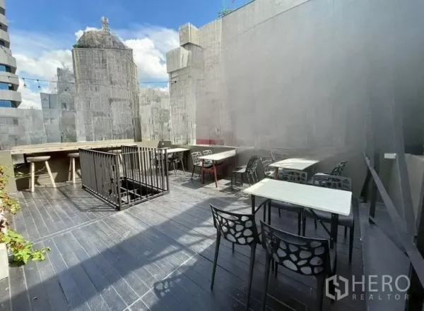 零售空间 出租在Watthana, Bangkok - 露天屋顶露台，摆放桌椅与吧台座位，可见城市景观