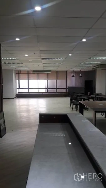 办公空间 出租在Huai Khwang, Bangkok - 大开间工作区，落地窗配卷帘，吊灯与内置长凳座位。