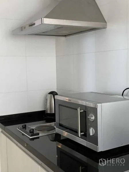 คอนโด ให้เช่าในKhlong Toei, Bangkok - ครัวกะทัดรัดท็อปหินแกรนิต เตาไฟฟ้า ไมโครเวฟ กาต้มน้ำ และฮูดสแตนเลส
