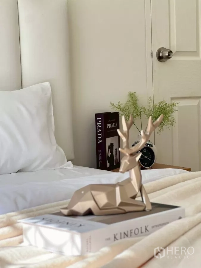 บ้าน ให้เช่าในHuai Khwang, Bangkok - มุมข้างเตียงประดับกวางตกแต่งวางบนหนังสือ พร้อมนาฬิกาปลุก