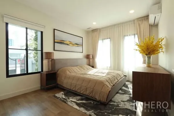 บ้าน ให้เช่าในSaphan Sung, Bangkok - ห้องนอนอบอุ่นพร้อมหน้าต่างบานใหญ่ พื้นไม้ โต๊ะหัวเตียง และภาพตกแต่งเหนือเตียง