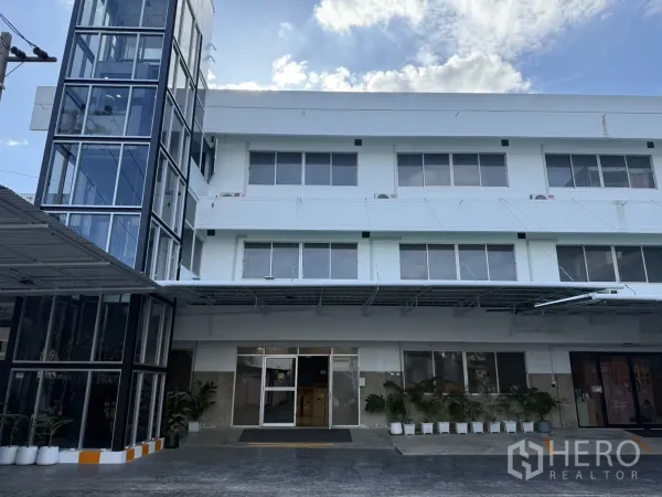 Office Space for rent in Wang Thonglang, Bangkok - Front facade of a three-storey office building with a glass-clad private elevator and driveway.