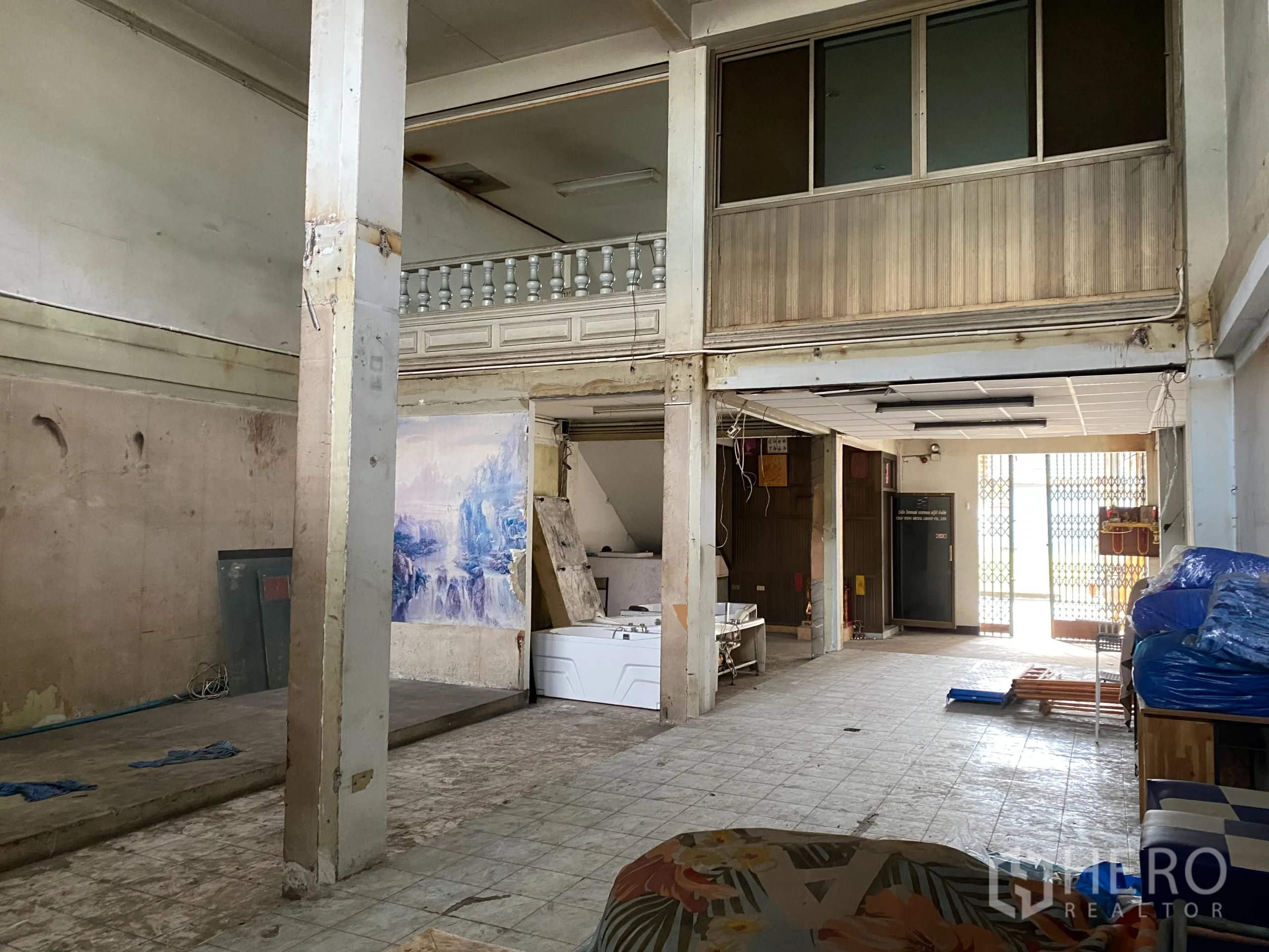 零售空间 出租在Yan Nawa, Bangkok - 一层零售大厅，立柱、夹层与前方栅栏式卷门。