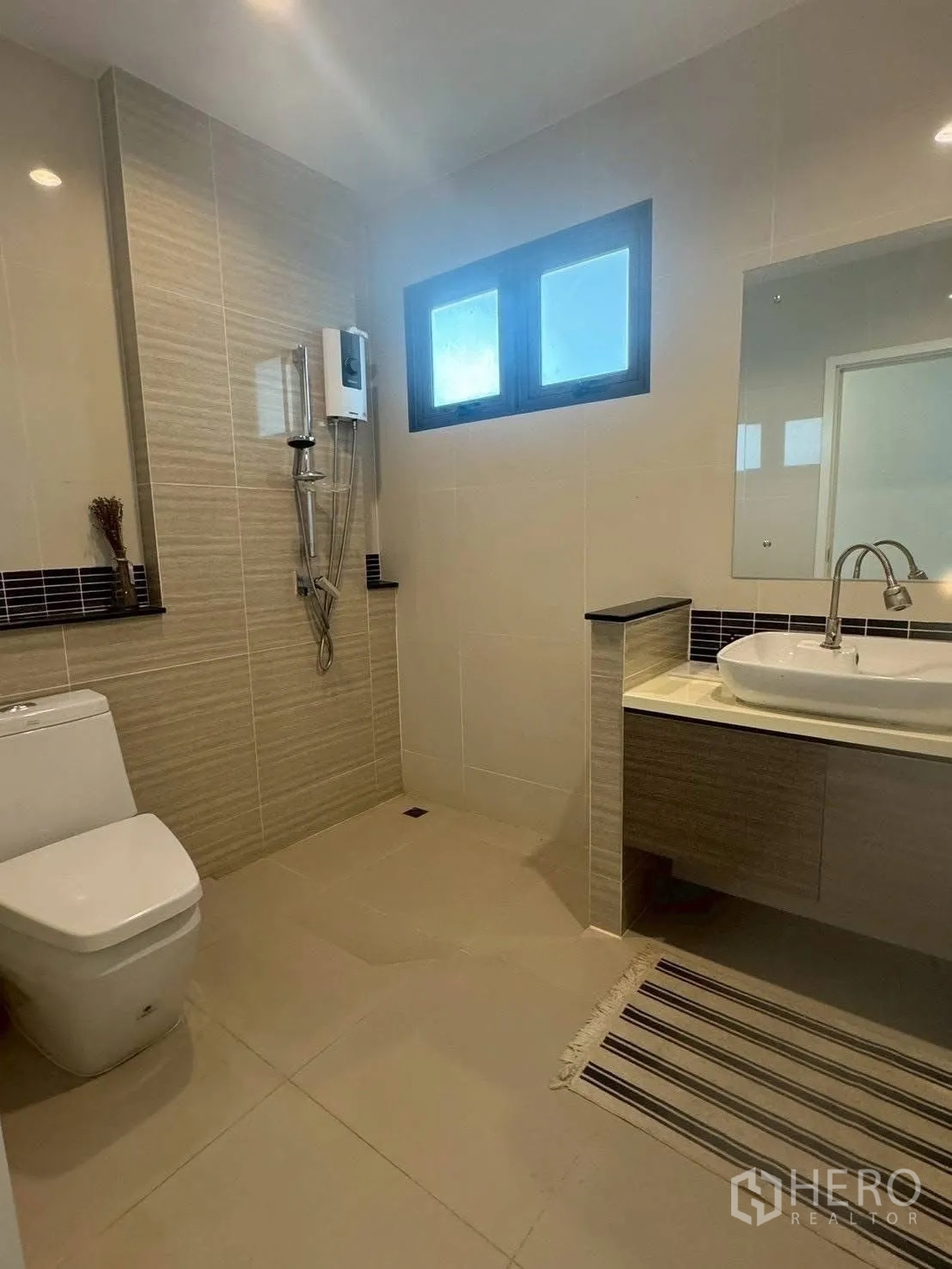 Detached House for rent or sale in Suan Luang, Bangkok - Tiled bathroom with toilet, vanity and shower with water heater.