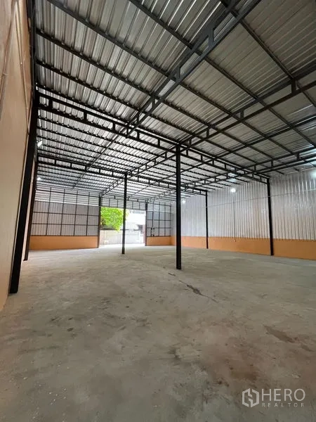 Warehouse for rent in Din Daeng, Bangkok - Open-span warehouse showing high ceiling, metal walls, and drive-in access to the entrance.