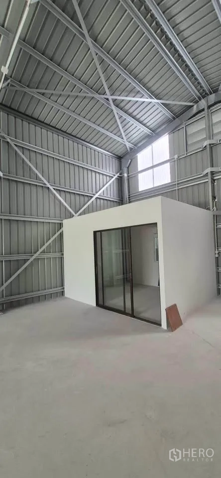Warehouse for rent in Lat Phrao, Bangkok - Interior of the warehouse featuring a white enclosed office with sliding glass doors.