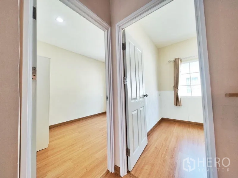 联排别墅 出租或出售在Phra Pradaeng, Samut Prakan - 二楼走廊连通两间采光卧室，均为木地板。