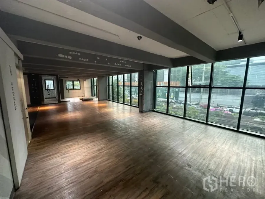 办公空间 出租在Bang Rak, Bangkok - 开放式办公区，整面落地窗、木纹地板与外露梁，享城市景观。