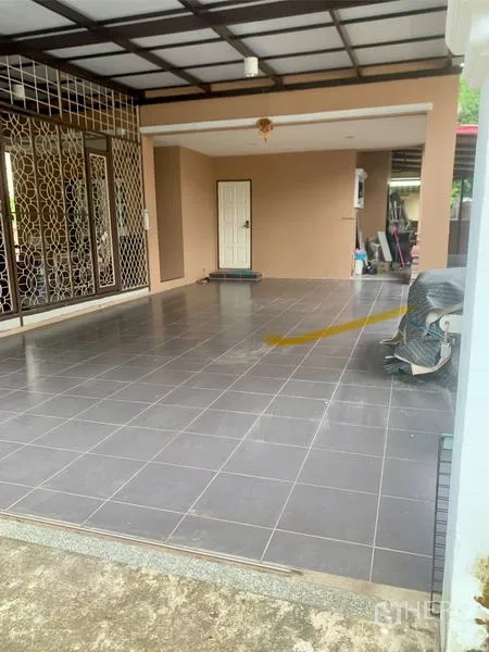 Detached House for rent in Khlong Sam Wa, Bangkok - Covered carport with gray floor tiles and decorative metal security grilles at the entrance.