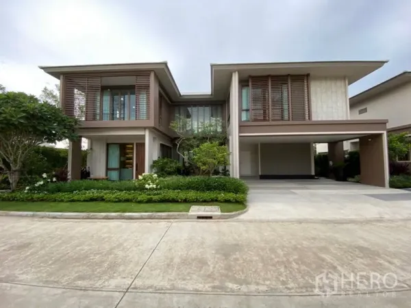 Detached House for sale in Bang Kapi, Bangkok - Modern two-storey detached house facade with timber louver screens, lush garden and wide driveway in Bang Kapi.