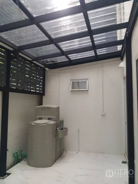 ทาวน์เฮาส์ ให้เช่าในKhlong Toei, Bangkok - ลานซักล้างด้านหลังมีหลังคาใส ถังเก็บน้ำ และอ่างล้างมือติดผนัง.