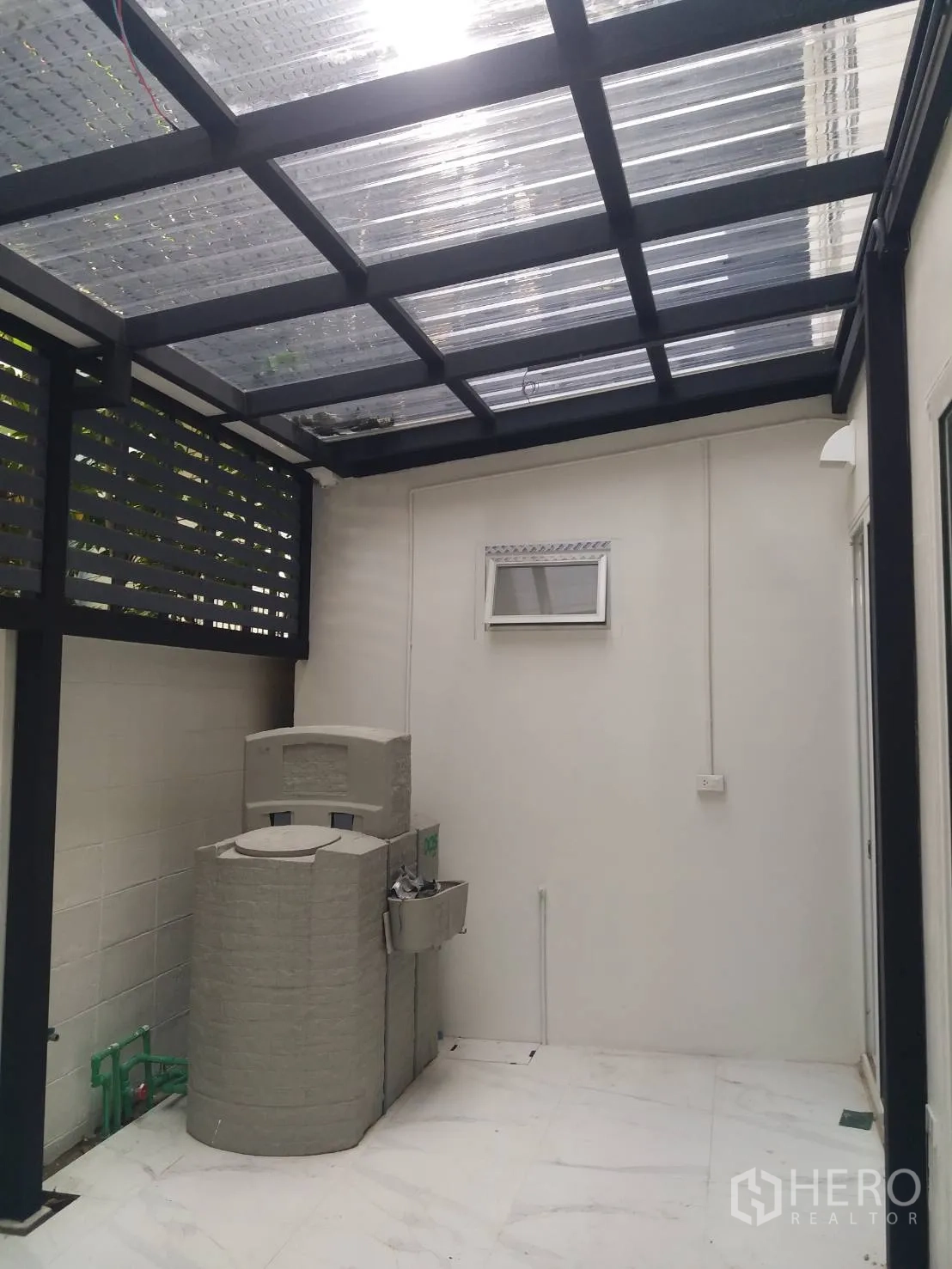 ทาวน์เฮาส์ ให้เช่าในKhlong Toei, Bangkok - ลานซักล้างด้านหลังมีหลังคาใส ถังเก็บน้ำ และอ่างล้างมือติดผนัง.