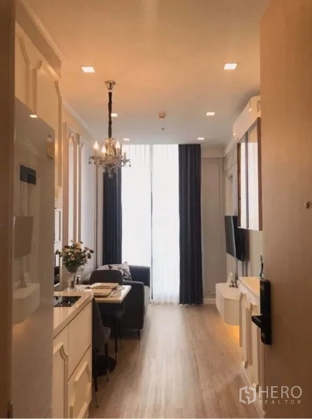 คอนโด ให้เช่าในWatthana, Bangkok - ห้องนั่งเล่นสไตล์โมเดิร์นอบอุ่น มีโคมระย้า ผนังทีวี และหน้าต่างเต็มผนัง ใกล้บีทีเอสพร้อมพงษ์