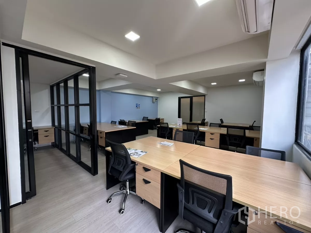 Office Space for rent in Watthana, Bangkok - Spacious open office with natural light, glass partitions and light wood flooring.