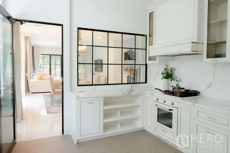 บ้าน ให้เช่าหรือขายในSaphan Sung, Bangkok - ห้องครัวสว่างตา ตู้สีขาว เตาอบบิลท์อิน และช่องหน้าต่างมองไปห้องอาหาร