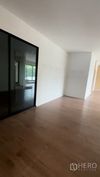 零售空间 出租在Bang Na, Bangkok - 走廊连接更多零售区域，白墙与木地面。