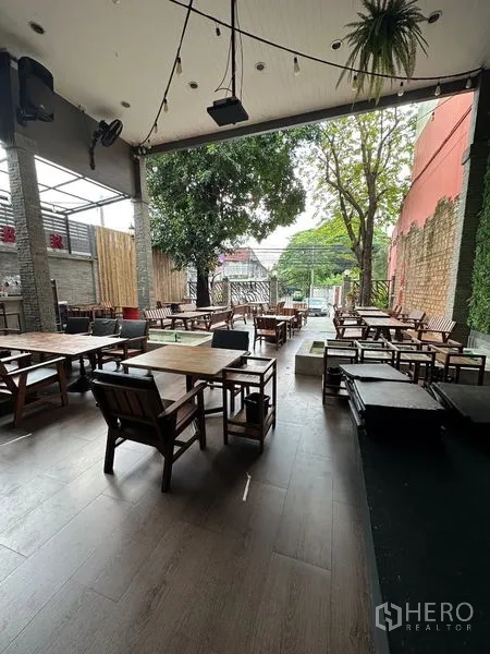 Retail Space for rent in Suan Luang, Bangkok - Covered terrace featuring many wooden tables, ceiling fans and a view toward the street and large tree.