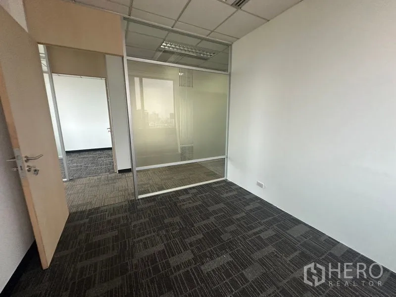 办公空间 出租在Khlong Toei, Bangkok - 小型办公室，磨砂玻璃隔断与格栅吊顶照明。