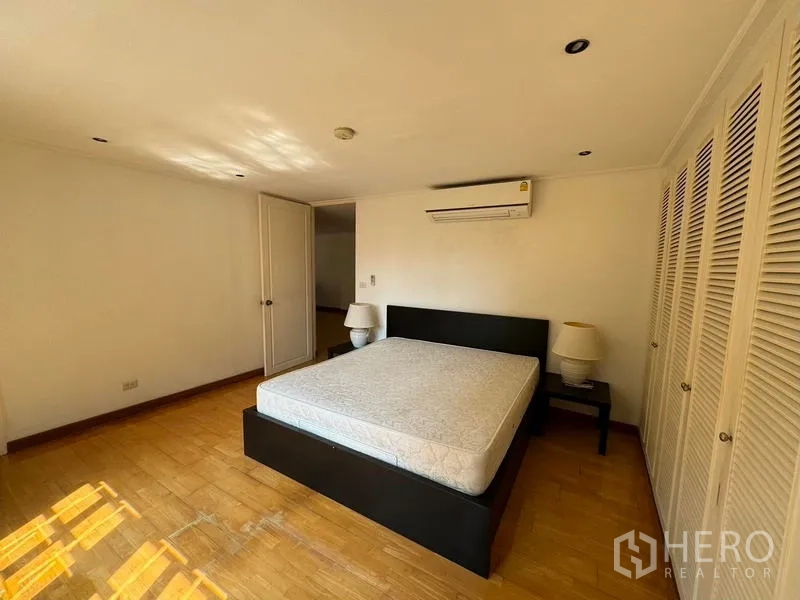 Condominium for rent in Yan Nawa, Bangkok - Bright master bedroom with bed, air-conditioning and built-in wardrobes.