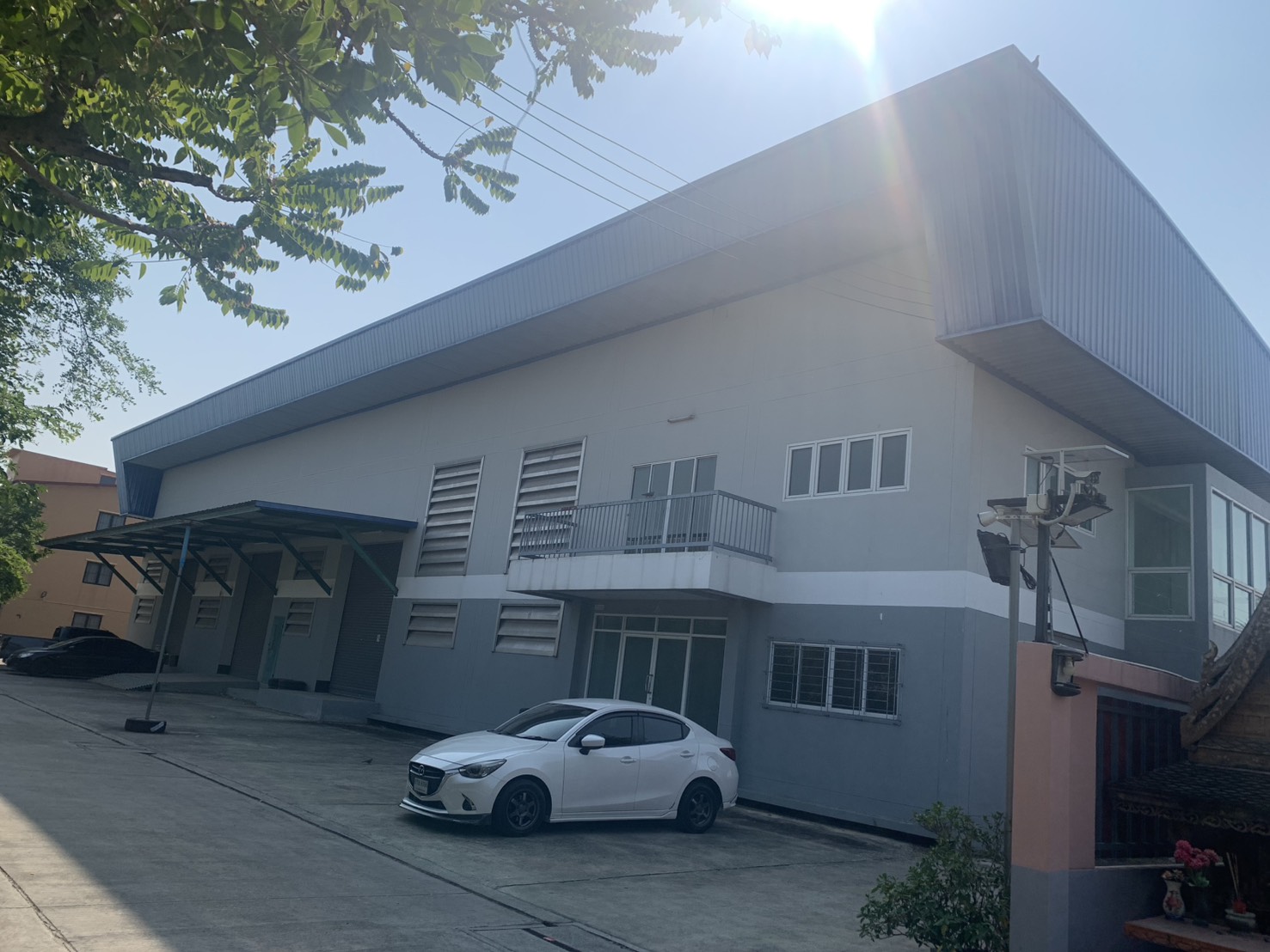 货栈 出租在Lam Luk Ka, Pathum Thani - 仓库外立面，带装卸月台、金属墙面与场内停车位。