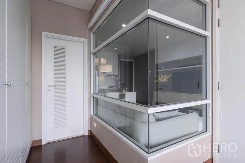 公寓 出租在Watthana, Bangkok - 走廊带玻璃隔断，可俯瞰客厅，并设白色收纳柜。