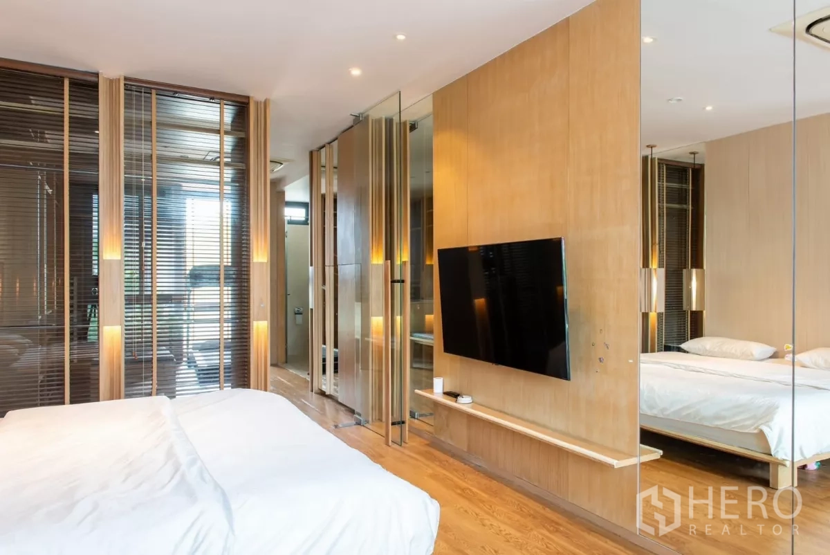 ทาวน์เฮาส์ ให้เช่าในLat Phrao, Bangkok - มุมมองห้องนอนพร้อมทีวีติดผนัง ฉากกั้นกระจกและแสงอบอุ่น