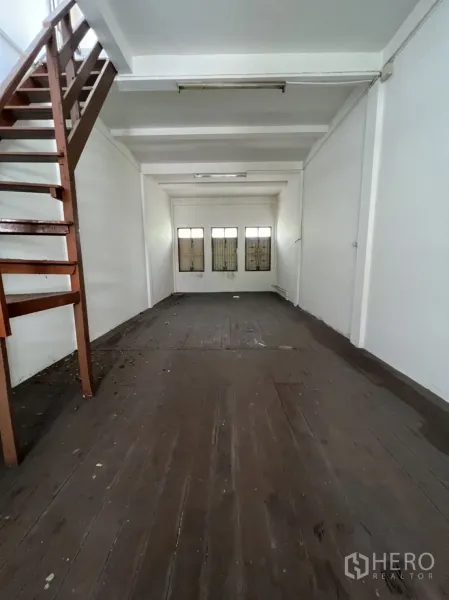 อาคารพาณิชย์ ให้เช่าในKhlong Toei, Bangkok - พื้นที่ชั้นบน พื้นไม้ หน้าต่างด้านหน้าพร้อมเหล็กดัด คานเพดานสีขาว และบันไดด้านข้าง