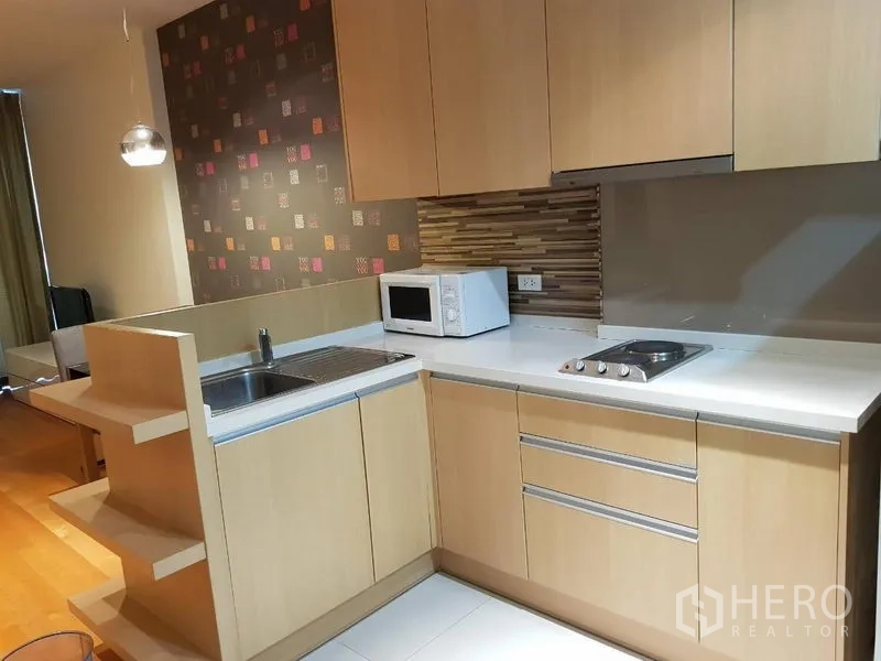 คอนโด ให้เช่าในRatchathewi, Bangkok - ครัวกะทัดรัด ตู้ไม้สีอ่อน อ่างล้างจาน เตาไฟฟ้า ไมโครเวฟ และผนังกันเปื้อน