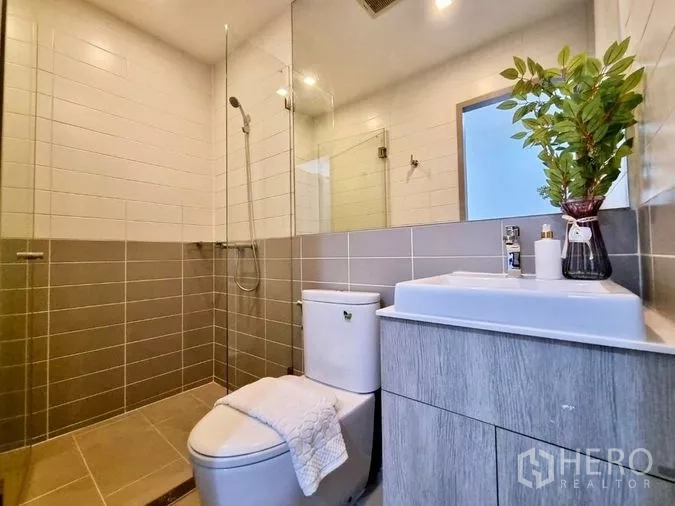 คอนโด ขายในPhra Khanong, Bangkok - ห้องน้ำสมัยใหม่พร้อมฝักบัวกระจก อ่างล้างหน้า และโถสุขภัณฑ์