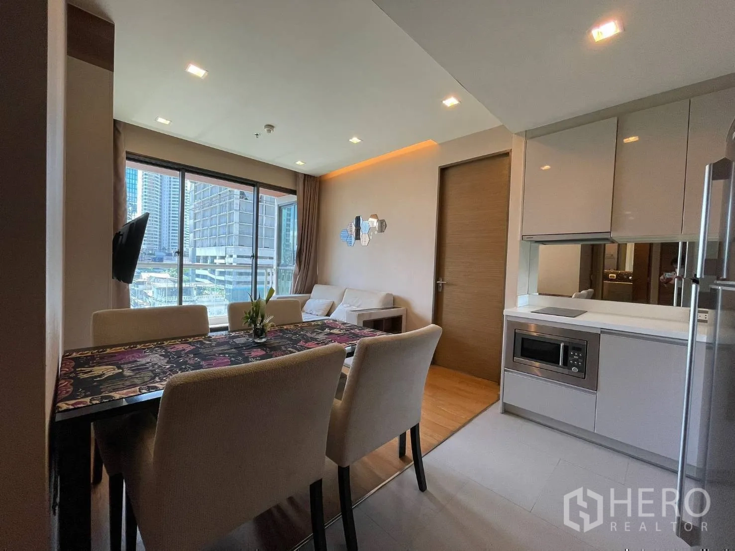 Condominium for rent or sale in Bang Rak, Bangkok - Dining and living area with four-seat table, sofa and balcony city view.